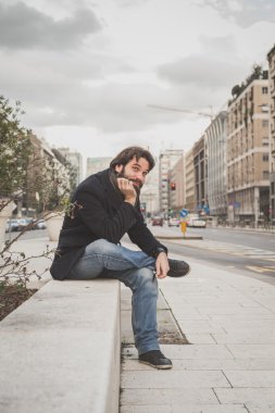 Genç yakışıklı sakallı adam şehir sokaklarını poz