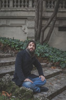 Genç yakışıklı sakallı adam şehir sokaklarını poz