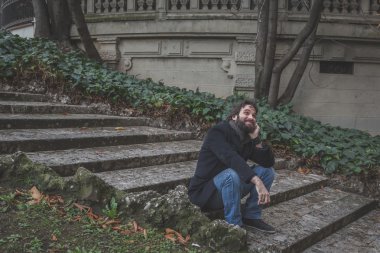 Genç yakışıklı sakallı adam şehir sokaklarını poz