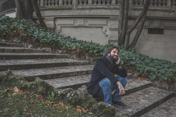 Genç yakışıklı sakallı adam şehir sokaklarını poz