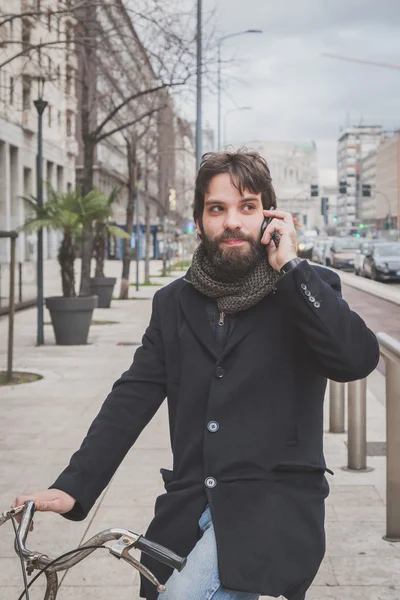 Genç yakışıklı sakallı adam telefonda konuşurken