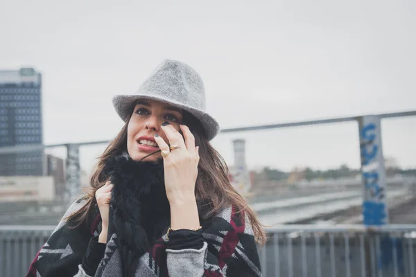 Krásná mladá brunetka pózuje v ulicích města — Stock fotografie