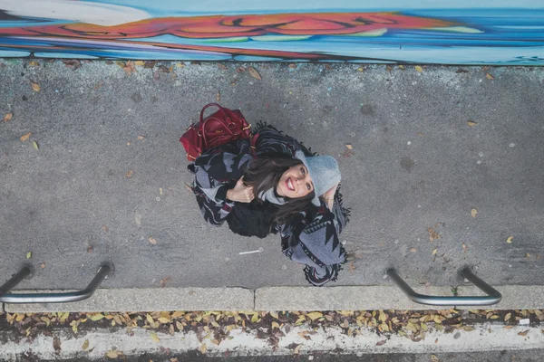 Topputsikt til en vakker ung brunette som poserer i byens gater – stockfoto