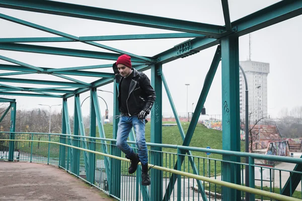 Punk guy jumping on a bridge — Stock Photo, Image