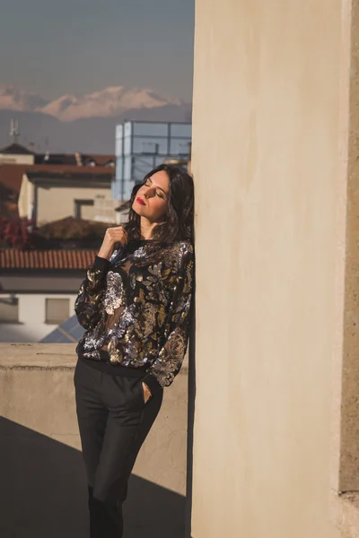 Portret van een mooie jonge brunette die zich voordeed op een balkon — Stockfoto