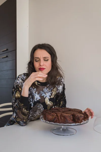 Beautiful young brunette posing with brownies — Stock Photo, Image