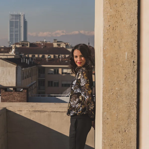 Portret van een mooie jonge brunette die zich voordeed op een balkon — Stockfoto