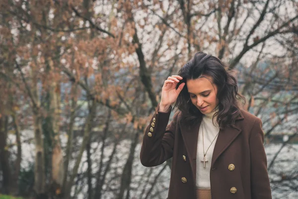 Beautiful young woman posing in a city park — Stock Photo, Image