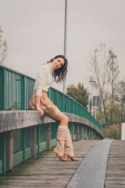 Beautiful young woman posing on a bridge — Stock Photo, Image