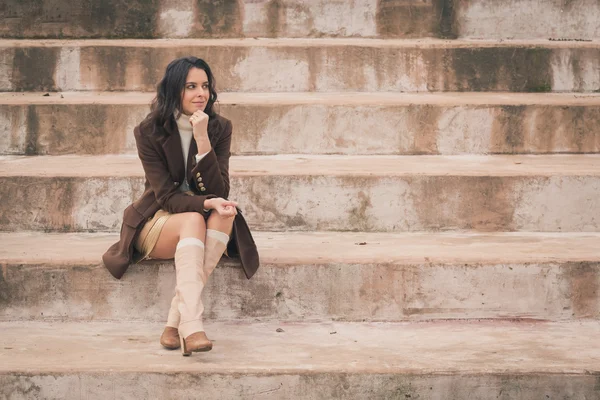 Belle jeune femme assise sur des marches en béton — Photo