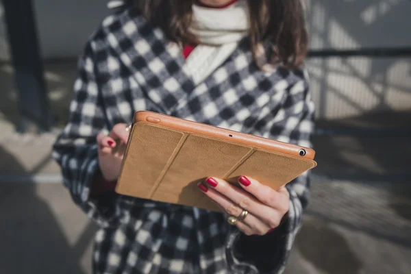 Dettaglio di una giovane donna che usa il suo tablet per le strade della città — Foto Stock