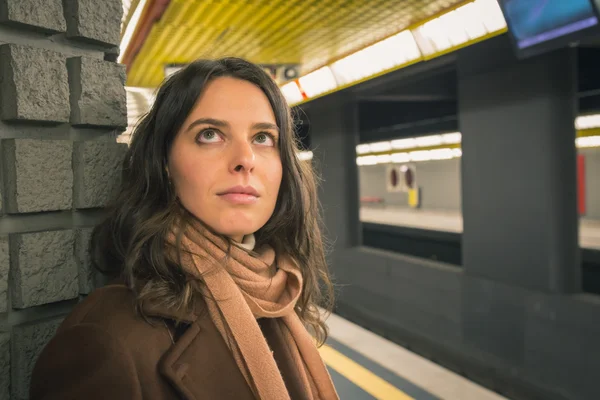 Beautiful young woman posing in a metro station — Stock Photo, Image