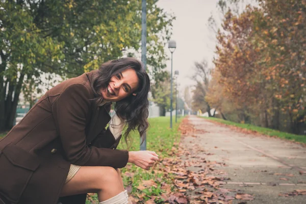 Beautiful young woman posing in a city park — Stock Photo, Image