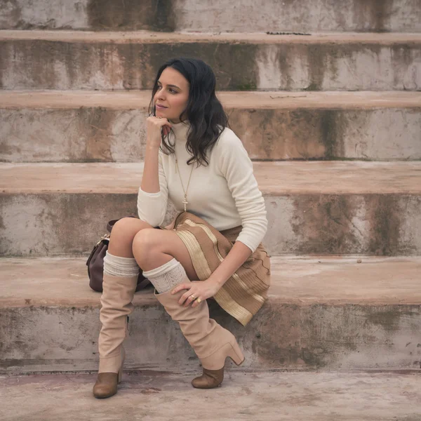 Красивая молодая женщина сидит на бетонных ступенях — стоковое фото