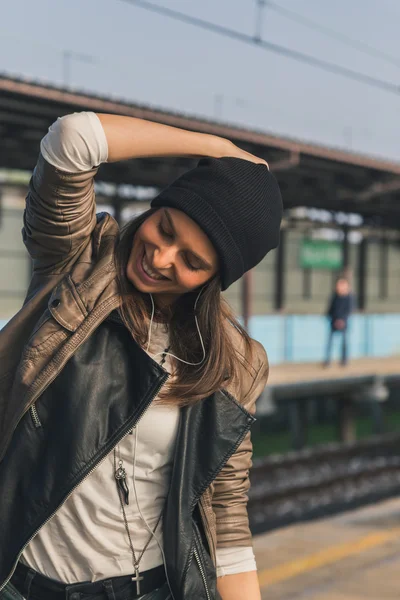 Pretty girl listening to music in a metro station — Stock Photo, Image