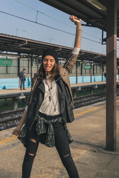 Söt flicka lyssna på musik i en tunnelbanestation — Stockfoto