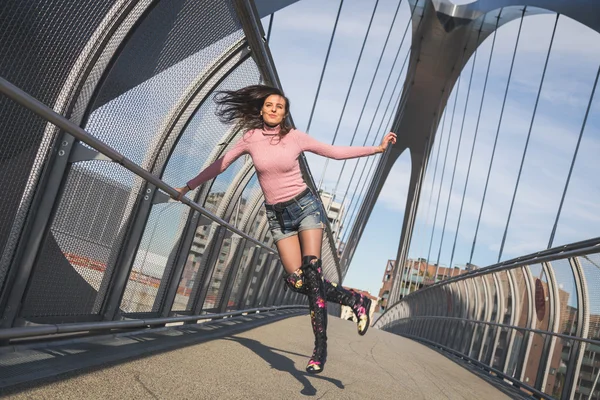 橋の上をジャンプの美しい若いブルネット — ストック写真