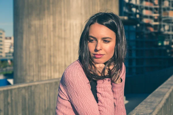 Piękna młoda brunetka pozowanie na ulicach miasta — Zdjęcie stockowe