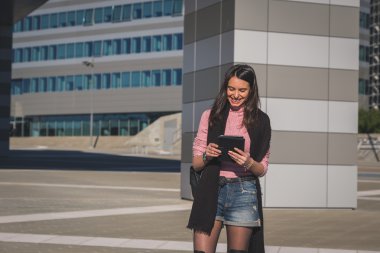 Onun tablet üzerinde çalışan güzel genç esmer