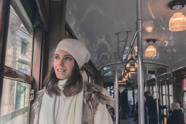 Beautiful young woman posing on a tram — Stock Photo, Image