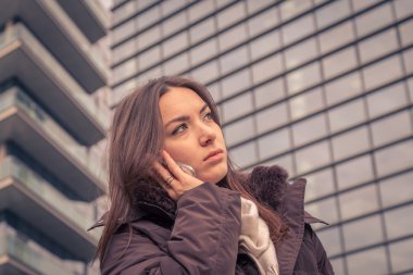 Şehir sokaklarında telefonda konuşurken genç güzel kız