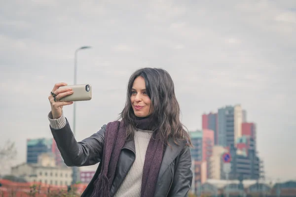 Gadis berambut cokelat yang cantik mengambil foto selfie di jalan-jalan kota — Stok Foto