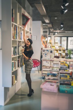 Güzel genç esmer bir kitapçıda poz