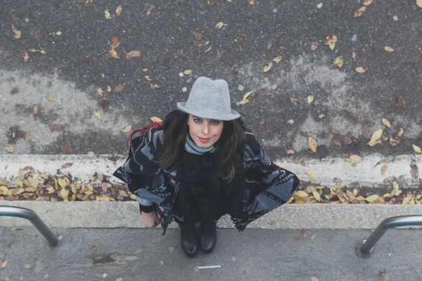 Top view of a beautiful young brunette posing in the city streets — Stock Photo, Image