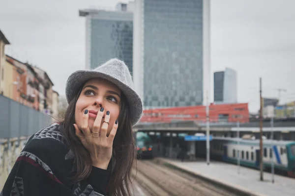 Krásná mladá brunetka pózuje v ulicích města — Stock fotografie