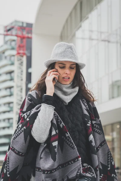 Красивая юная брюнетка разговаривает по телефону на улицах города — стоковое фото