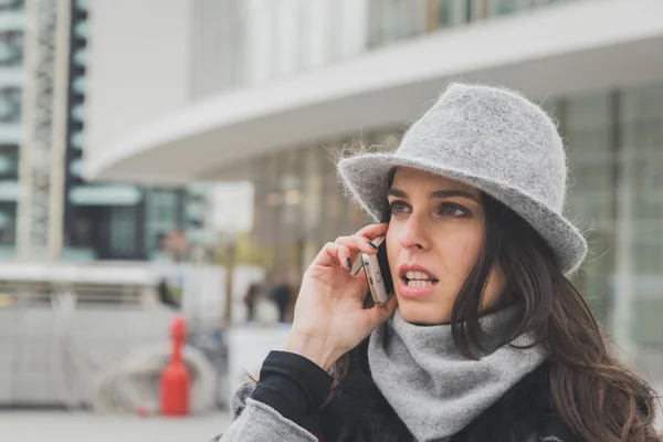 Piękna młoda brunetka rozmowy na telefon na ulicach miasta — Zdjęcie stockowe