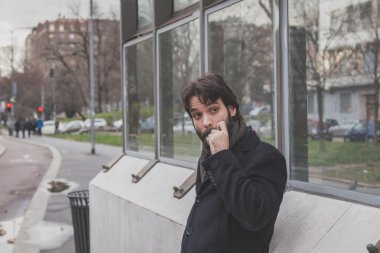 Genç yakışıklı sakallı adam şehir sokaklarını poz