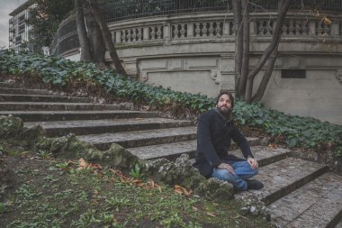 Genç yakışıklı sakallı adam şehir sokaklarını poz