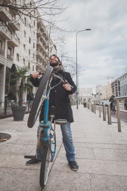 Genç yakışıklı sakallı adam onun bisiklet ile poz