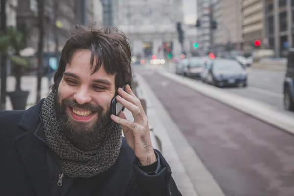 Mladý pohledný vousatý muž mluví na telefonu — Stock fotografie
