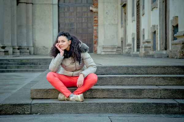 Krásná mladá brunetka pózuje v ulicích města — Stock fotografie