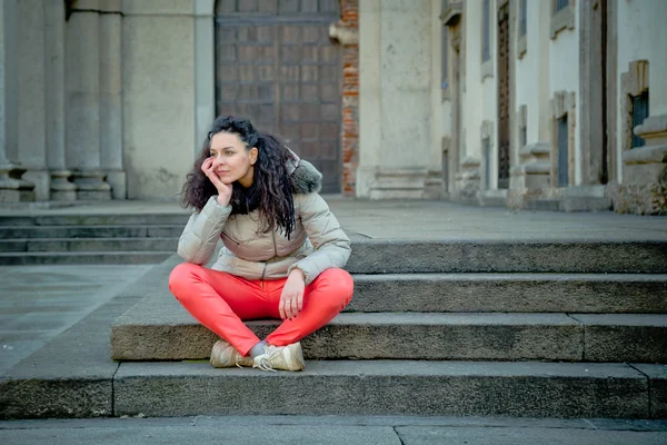 Schöne junge Brünette posiert in den Straßen der Stadt — Stockfoto