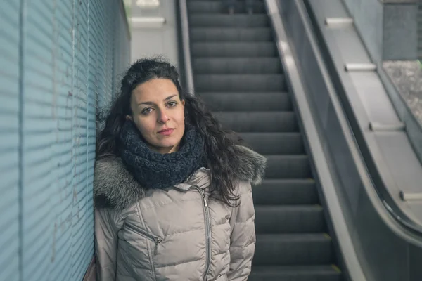 Vacker ung brunett poserar i en tunnelbanestation — Stockfoto