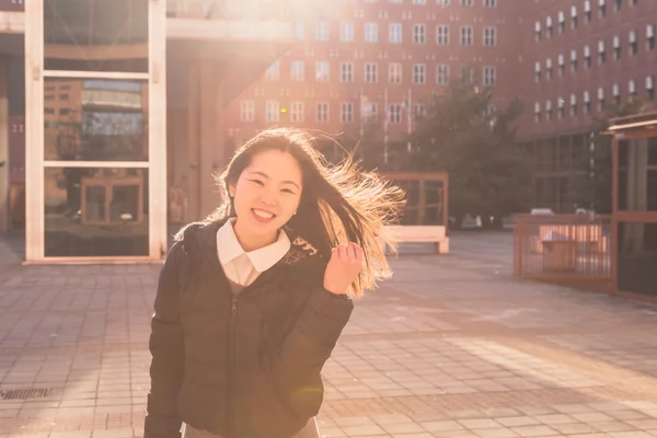 Young beautiful Chinese girl posing in the city streets — Stock Photo, Image