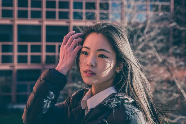 Young beautiful Chinese girl posing in the city streets — Stock Photo, Image