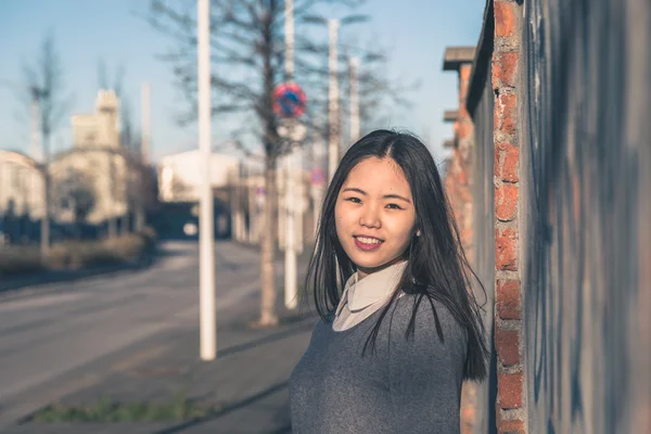 Young beautiful Chinese girl posing in the city streets — Stock Photo, Image