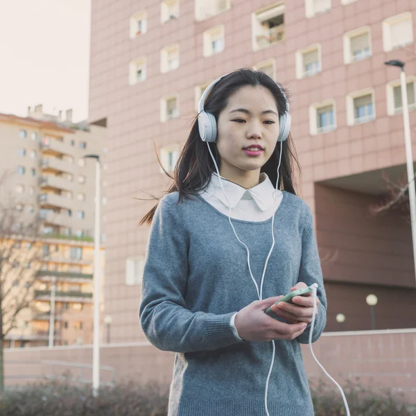 Young beautiful Chinese girl with headphones — Stock Photo, Image