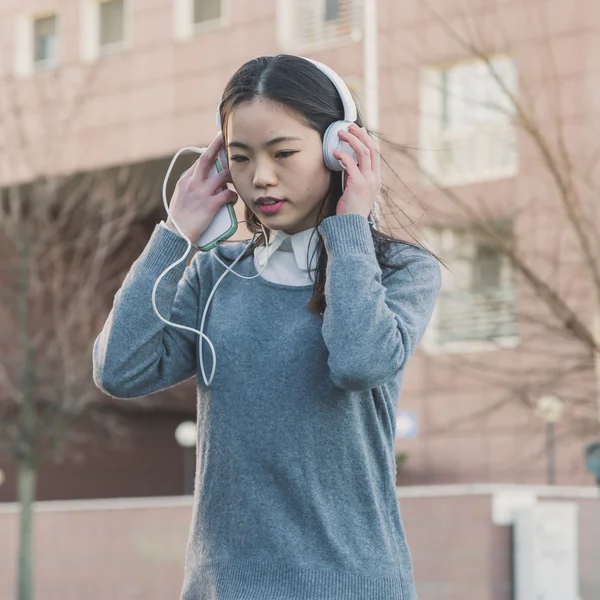Joven hermosa chica china con auriculares — Foto de Stock