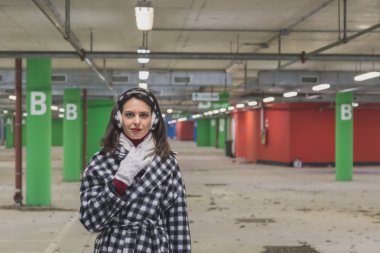 Güzel genç esmer bir otoparkta poz