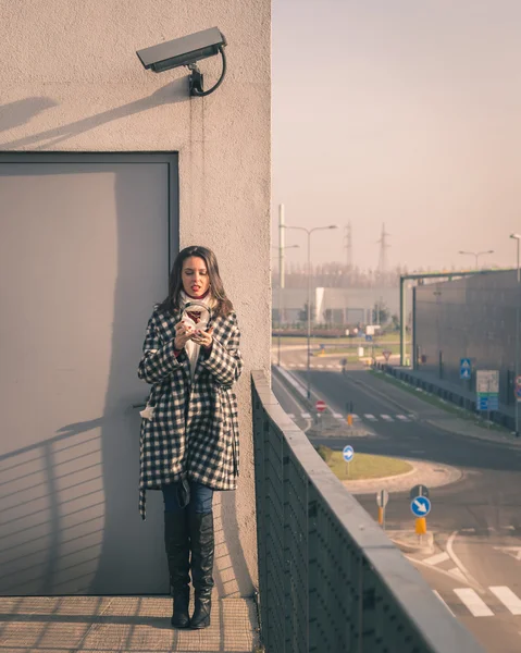 Beautiful young brunette posing in the city streets — Stock Photo, Image