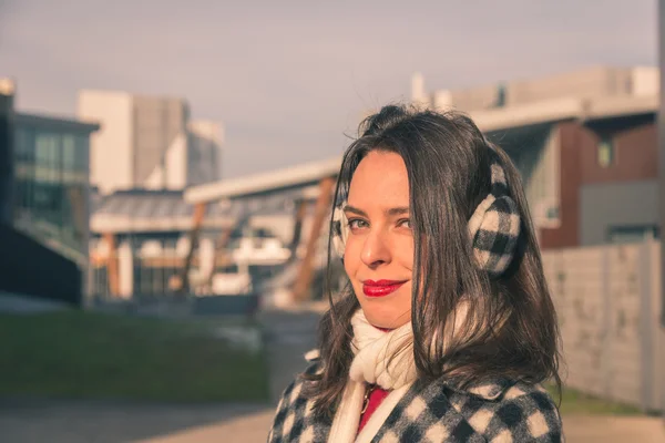 Krásná mladá brunetka pózuje v ulicích města — Stock fotografie