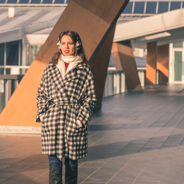 Krásná mladá brunetka pózuje v ulicích města — Stock fotografie