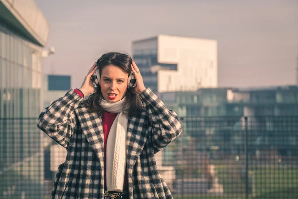 Krásná mladá brunetka pózuje v ulicích města — Stock fotografie