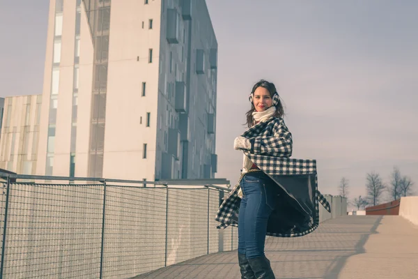 Krásná mladá brunetka pózuje v ulicích města — Stock fotografie