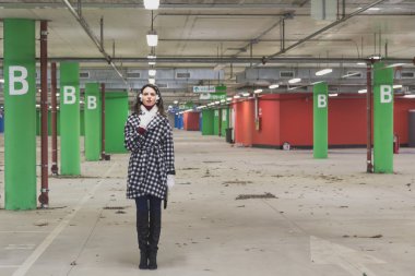 Güzel genç esmer bir otoparkta poz